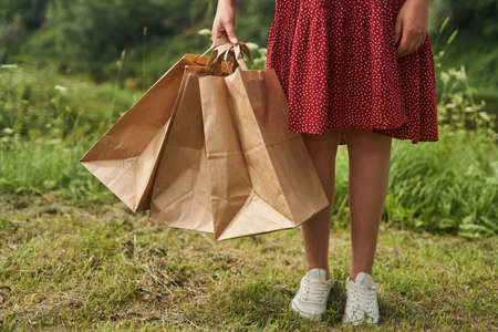 A young girl holds blank paper bags in her hand. Shopping conceptの写真素材