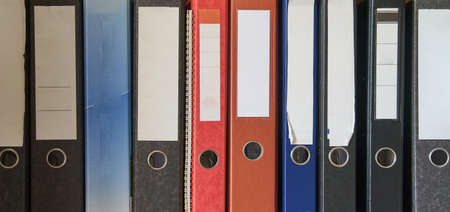 Colored folders for office files and paper on a shelf. Background image