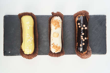Three eclairs on a black tray top viewの写真素材