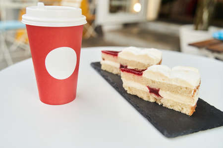 Paper cup of coffee with dessert. Coffee with cake on white tableの写真素材
