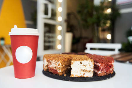 Paper cup of coffee with dessert. Coffee with cake on white table