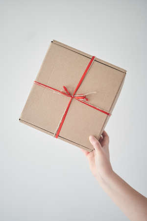 Selected focus. Girl holding a gift box with a red ribbon in her hands