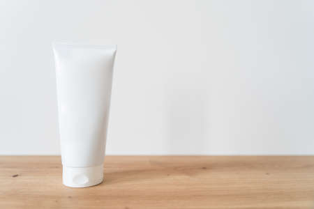 White tube cream mockup on a wooden table.の写真素材