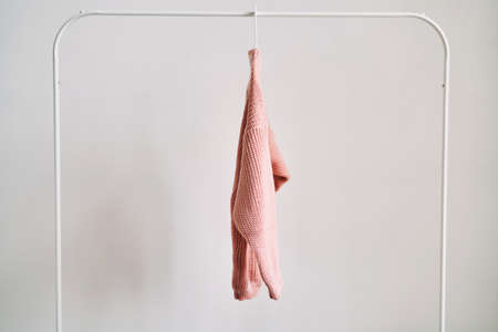A woolen sweater hanging on a hanger on a white background. Warm clothes sale.の写真素材