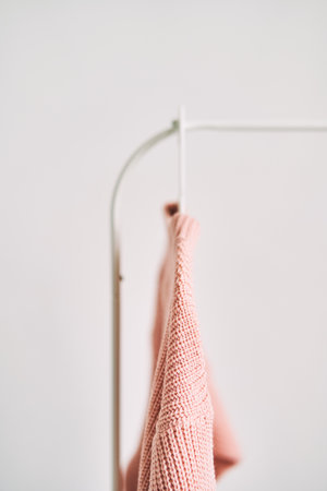 A woolen sweater hanging on a hanger on a white background. Warm clothes sale.の写真素材