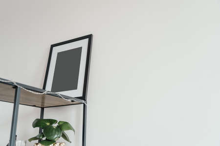 Blank wooden photo frame stands in the interior on a white background. Mockup poster frame.の写真素材