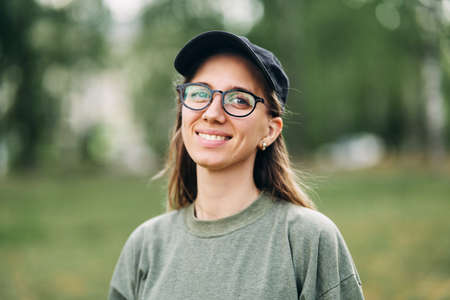 Portrait of a smiling young girl with glasses in the parkの写真素材