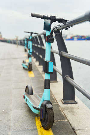 Electric scooters for rent, docked on the embankment.の写真素材
