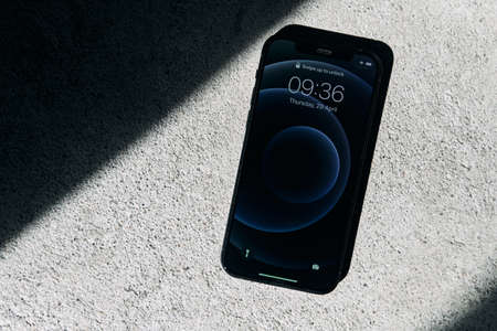 Kaliningrad, Russia - April 15, 2021: Black Apple iPhone 12 on a gray background. Latest model...