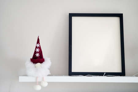 Blank wooden photo frame stands in the interior on a white background. Mockup poster frame close up in home interior.の写真素材