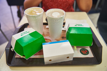 Moscow, Russia - 30.07.2022: Burgers and drinks on a tray. Food at Vkusno and tochka. Rebranding of the popular McDonalds fast food chain in Moscow, Russiaのeditorial素材