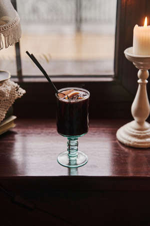 Traditional winter festive alcoholic drink. A glass of mulled wine is on the window.の写真素材