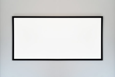 An empty photo frame with a black border hanging on a white wall