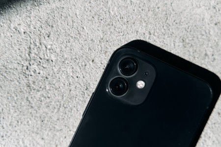 Kaliningrad, Russia - April 15, 2021: Black Apple iPhone 12 on a gray background. Latest model phone.のeditorial素材