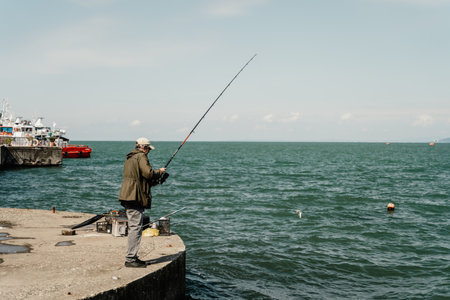 Batumi, Georgia - 04.05.2021: Fisherman fishing near Batumi seaportのeditorial素材