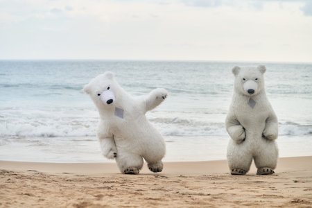 Animators dressed as polar bears entertain people on the beach