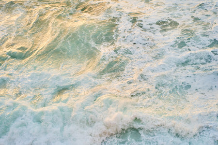 a close up of a body of water with waves crashing on the shoreの写真素材