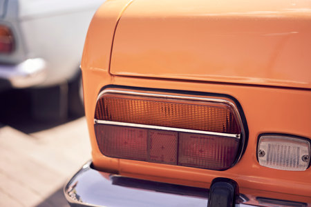 A vintage car tail light illuminates a cobbled street, embodying classic automotive aestheticsの写真素材