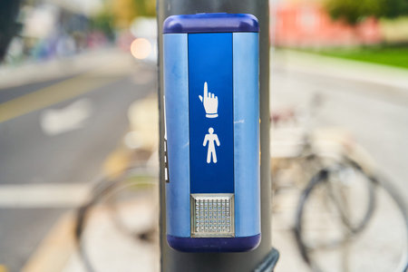 An urban scene with a pedestrian signal button and a bicycle in a bustling environment
