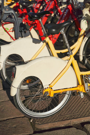 Row of bicycles neatly parked in lot, tires and wheels alignedの写真素材