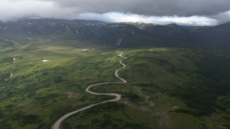 Aerial View of a Beautiful Winding River Surrounded by Lush Green Hills and Natureの写真素材
