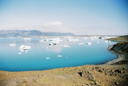 Icebergs in a blue glacial lake in Iceland. Grainy film in the style of old photos