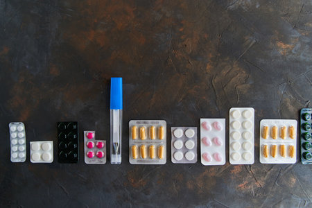 Pills capsules medicine health on dark background, top view