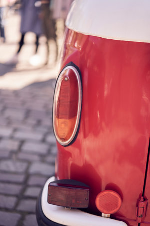 A vintage car tail light illuminates a cobbled street, embodying classic automotive aestheticsの写真素材
