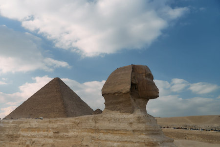 The iconic Great Sphinx and Pyramid stand majestically beneath a dramatically cloudy sky