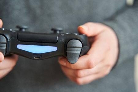 Joystick for game console. The person plays in the console. Close-up.