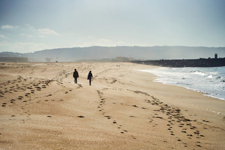 Enjoy a Serene Beach Walk at Sunset, Embraced by Gentle Waves Amidst Natures Beautyの写真素材