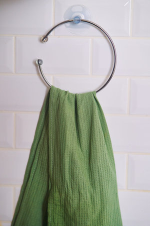 Green towel hanging on a metal hook