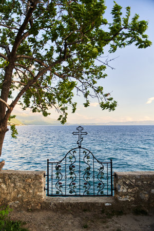 Lake view behind the metal fence with orthodox cross in Ohrid, North Macedoniaの写真素材