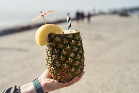 Delicious Tropical Pineapple Drink garnished with a colorful Umbrella and a Banana Sliceの写真素材