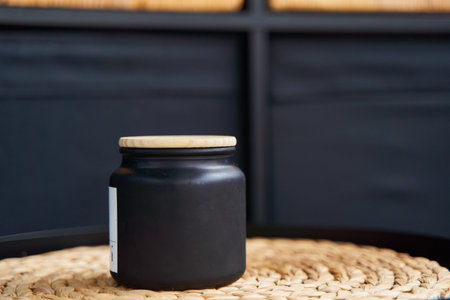 Stylish black jar with a wooden lid for a candle or creamの写真素材