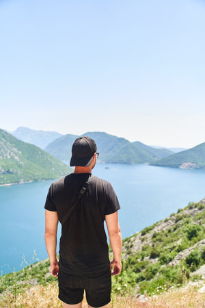 a young man admires the Bay of Kotor. Photo from the backの写真素材