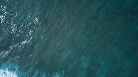 Aerial view of the ocean and surfer man.