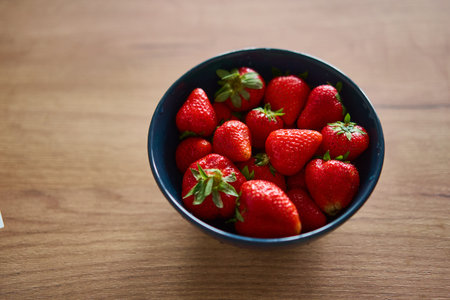 A Charming Bowl Full of Fresh and Ripe Strawberries Placed on a Rustic Wooden Table