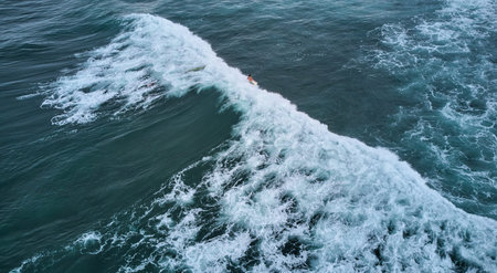 Aerial view of the ocean and surfer girl.