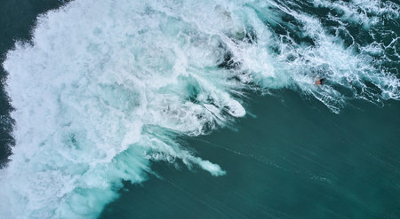 Aerial view of the ocean and surfer girl.