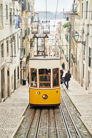 Lisbon, Portugal - 29.12.2022: A preserved Vintage Yellow Tram travels through Lisbons enchanting Historic Neighborhoodのeditorial素材