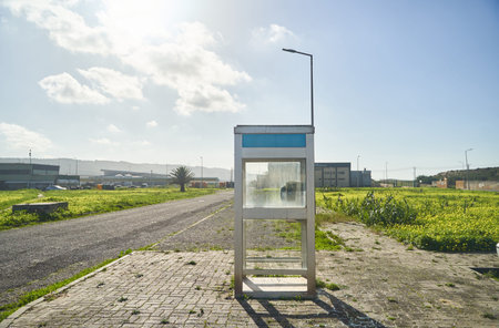 Nazare, Portugal - 27.12.2022: A phone booth sits by the roadside in a field under the open sky