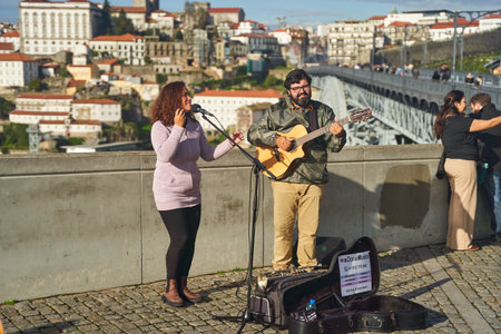 Porto, Portugal - December 27, 2022: Musician playing guitar and woman singing at concert in buildingのeditorial素材