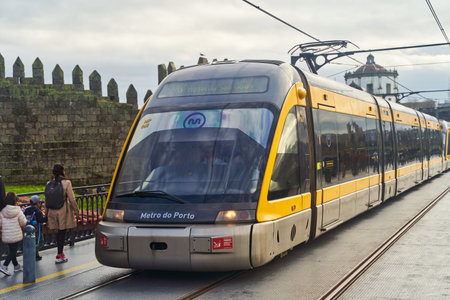 Porto, Portugal - December 27, 2022: A modern tram arrives at Porto Station, blending historic architecture with contemporary transportのeditorial素材