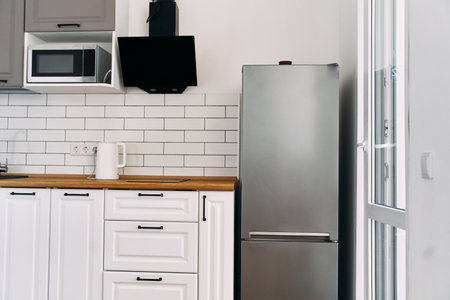 White cabinets with wooden counter of modern kitchenの写真素材