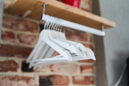 Many wooden white hangers on a rod. Empty hanger.の写真素材