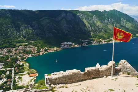 The flag of Montenegro develops in the wind. View from the Kotor Fortressの写真素材