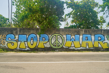 Midigama, Sri-lanka - 25.03.2022: Graffiti on the wall Stop war made in the colors of the flag of Ukraine. Graffiti dedicated to events in Ukraine