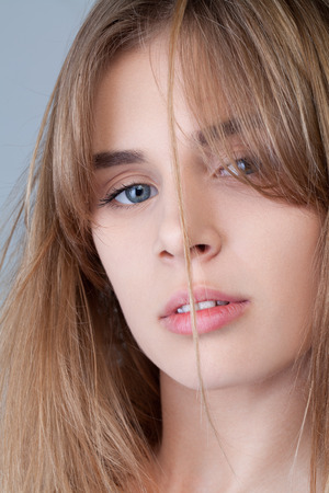 Beauty studio portrait of blond girl with long straight hair with natural makeup. Vogue style portait. Hairstyle and skincare and cosmetics conceptの写真素材