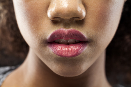 Beauty. Close up Beautiful girl Face With soft color Lipstick. Sexy Full Lips. Horizontal Portrait Of Female Black Model With natural Makeup. Cosmetics Concept. Skincare conceptの写真素材